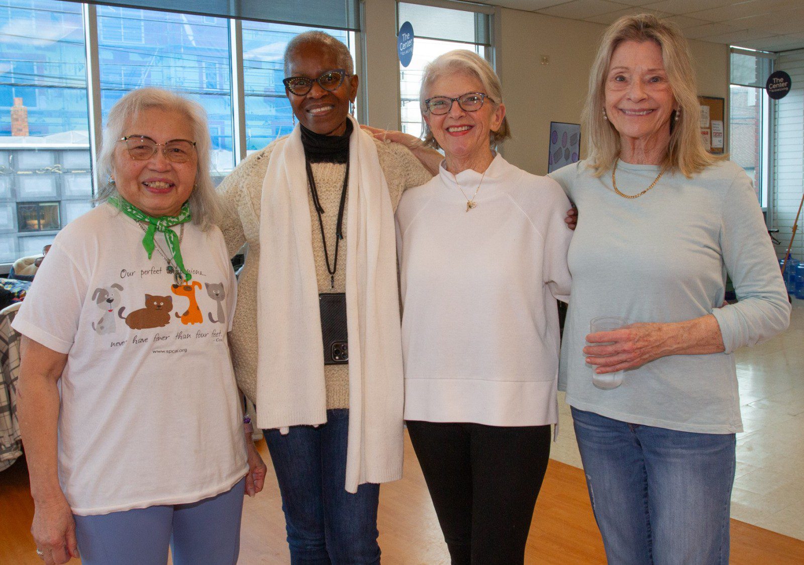 Four women stand together at The Center in Hatten Hall smiling at the camera