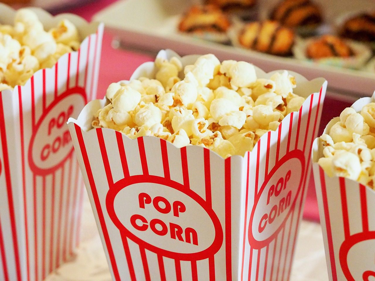 Close-up of three striped popcorn containers filled with popcorn