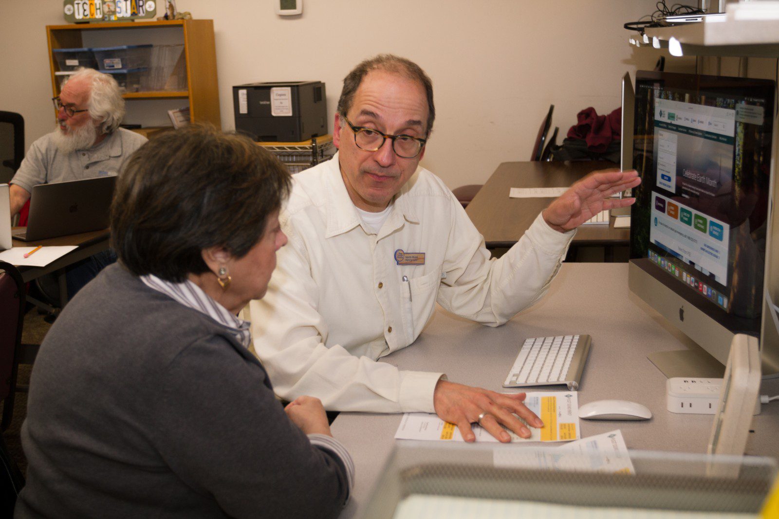 Staff member Martin helps someone in the computer lab