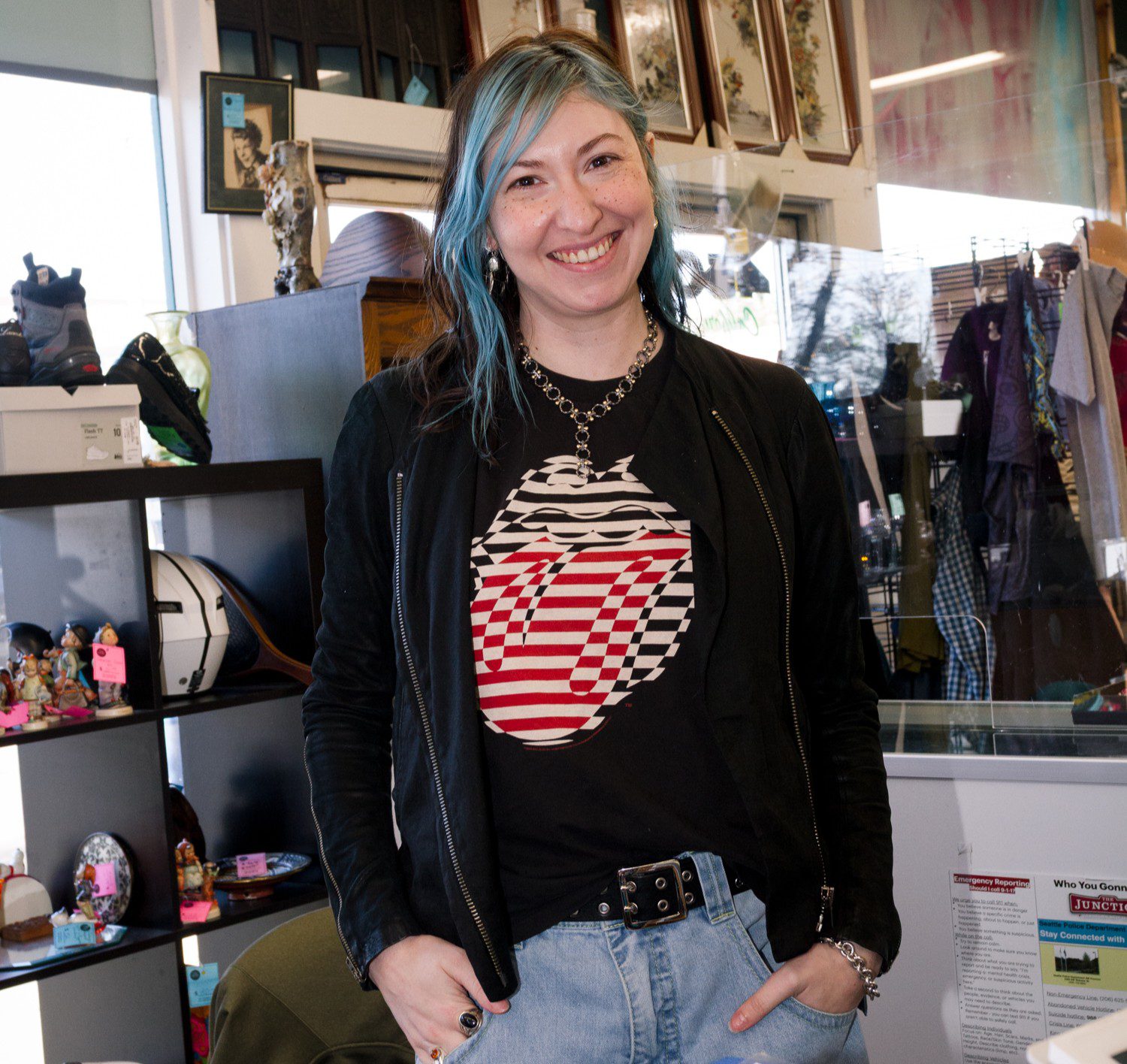 Photo of staffer Yoni wearing a black sweater and smiling at the camera in the Thrift Store