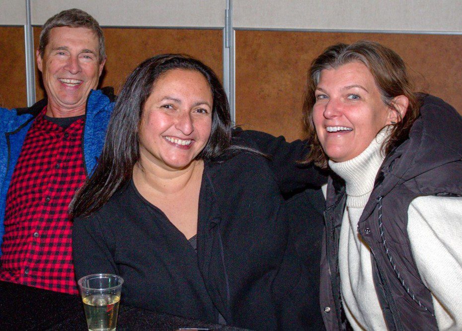 Three people at Jazz Night enjoying wine and music