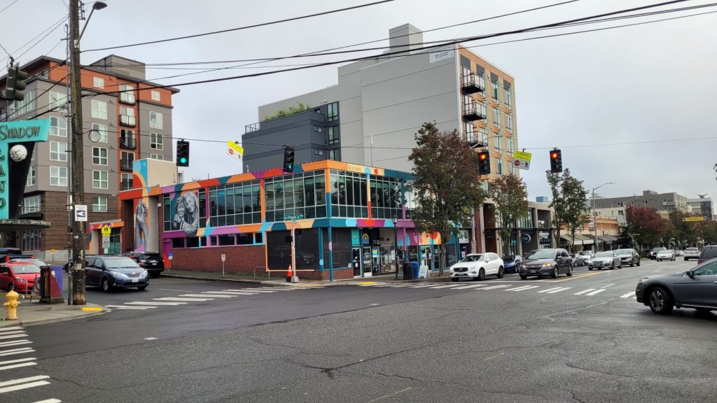 Wide shot of the West Seattle Junction with cars and crosswalks. The Center for Active Living is in the middle.