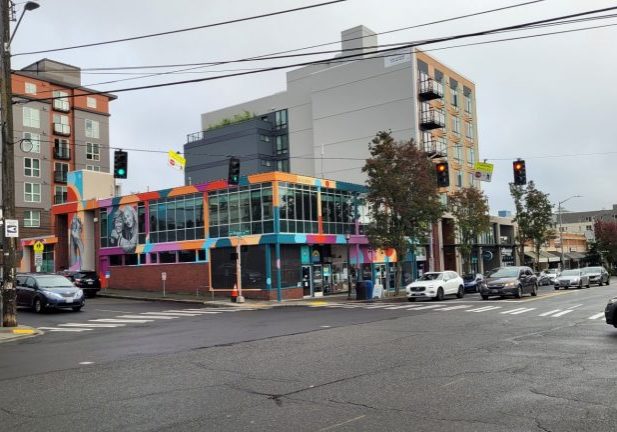 Wide shot of the West Seattle Junction with cars and crosswalks. The Center for Active Living is in the middle.