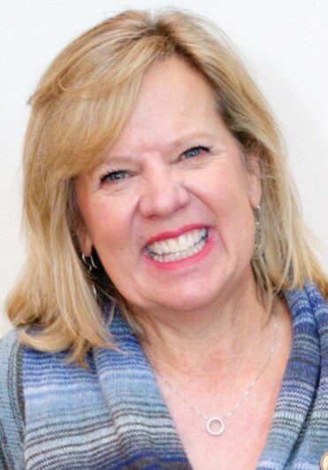 Headshot of Laurie, a woman with blonde hair smiles at the camera