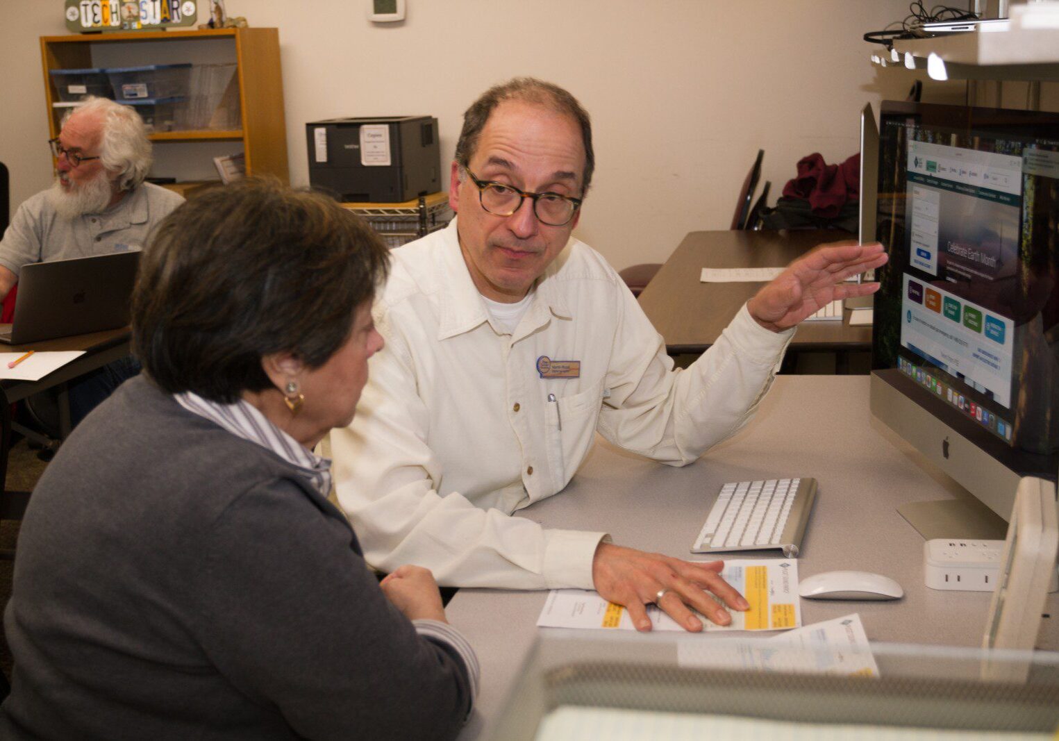 Staff member Martin helps someone in the computer lab