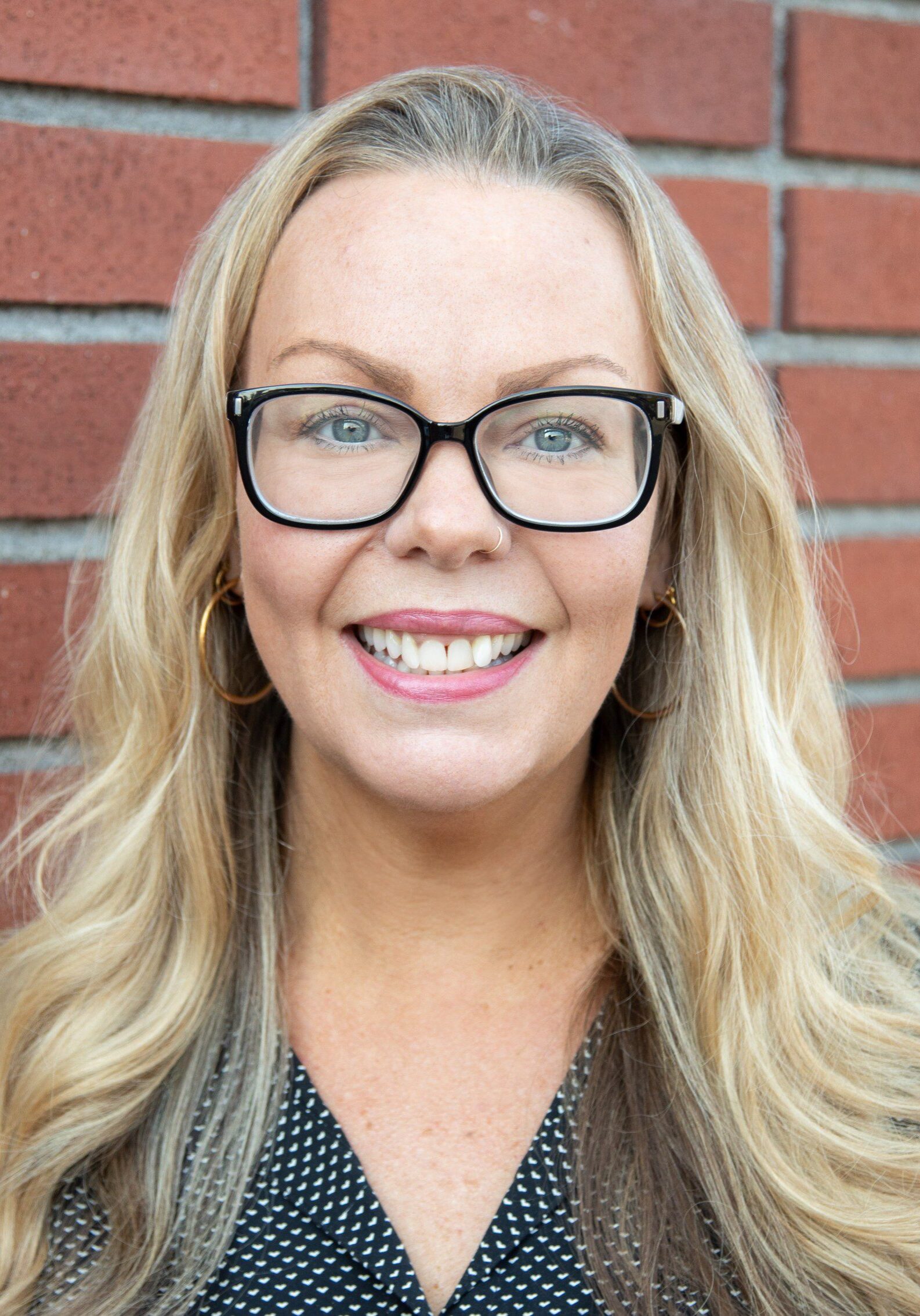 Heather wearing glasses and smiling.