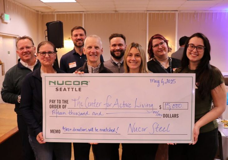 Employees from Nucor holding a large check for $15,000 from Nucor Seattle made out to The Center for Active Living
