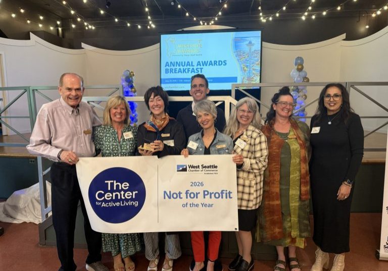 Group photo of staff and volunteers holding a banner and award at the ceremony