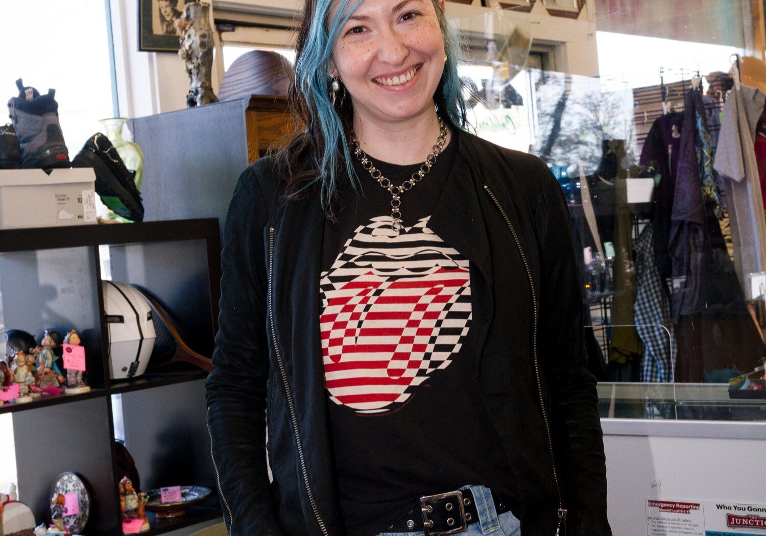 Photo of staffer Yoni wearing a black sweater and smiling at the camera in the Thrift Store